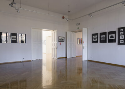 Sala wystawpwa po prawej stronie i na prost duże dwuskrzydłowe drzwi. Na scianach oprawione w ramy litografie.